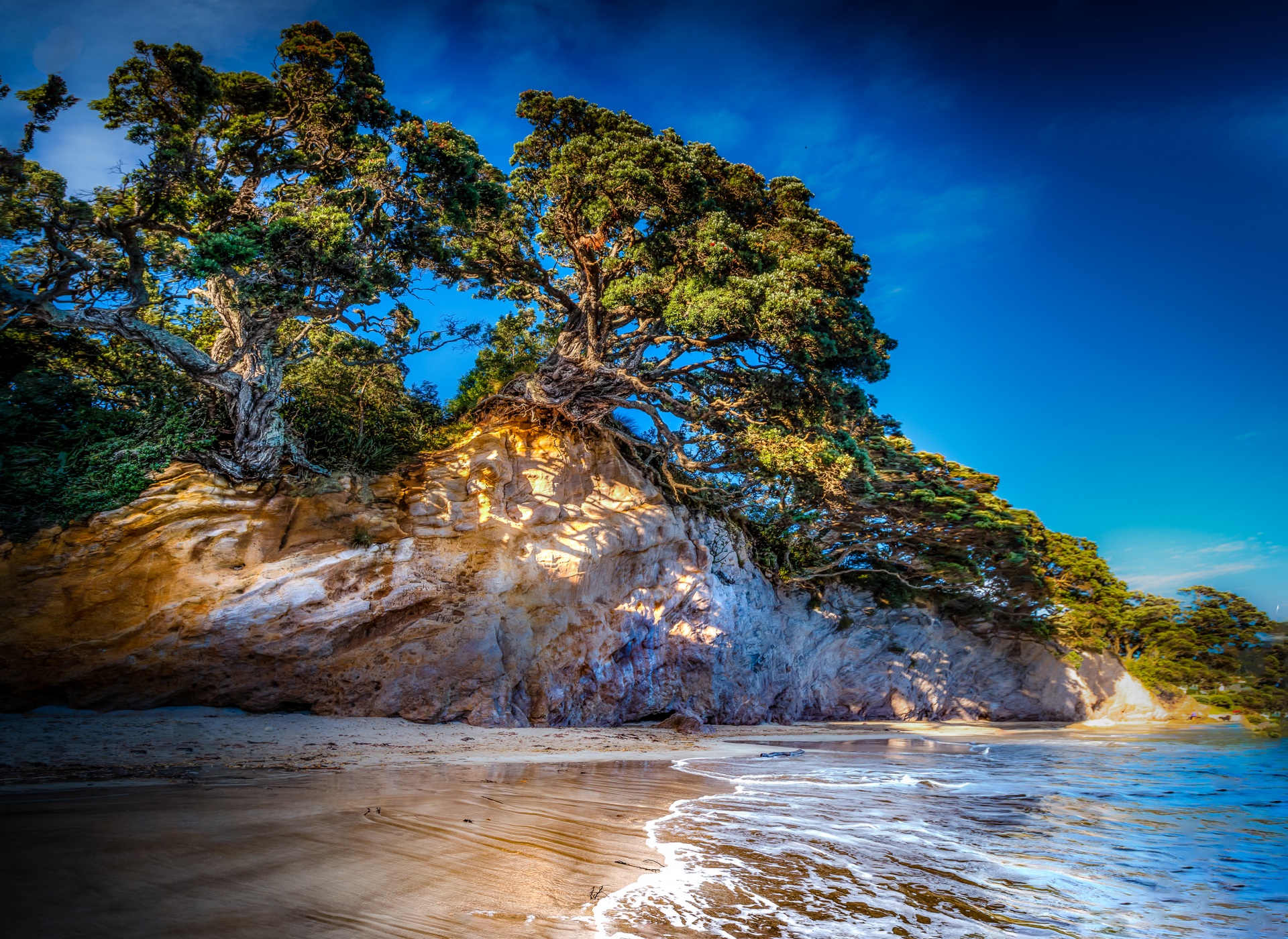 عکس امواج دریا روی ساحل شنی جزیره ای با صخره های زیبا برای زمینه لپ تاپ