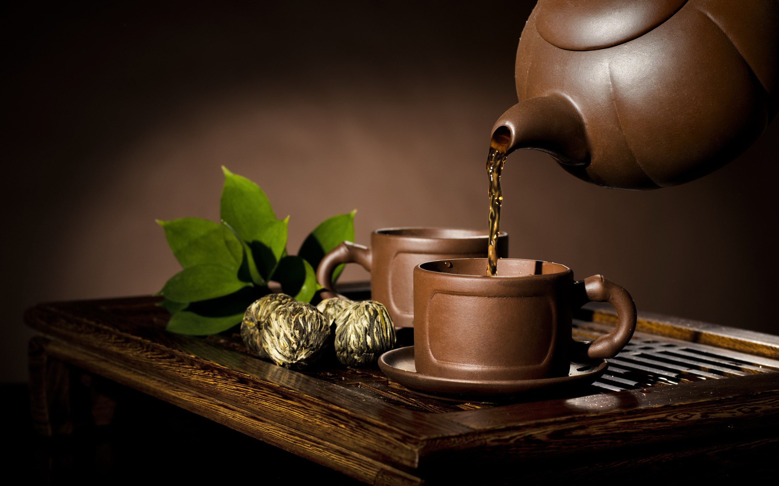 بک گراند خوشمنظر از فنجان و قوری چوبی درحال سرو چای