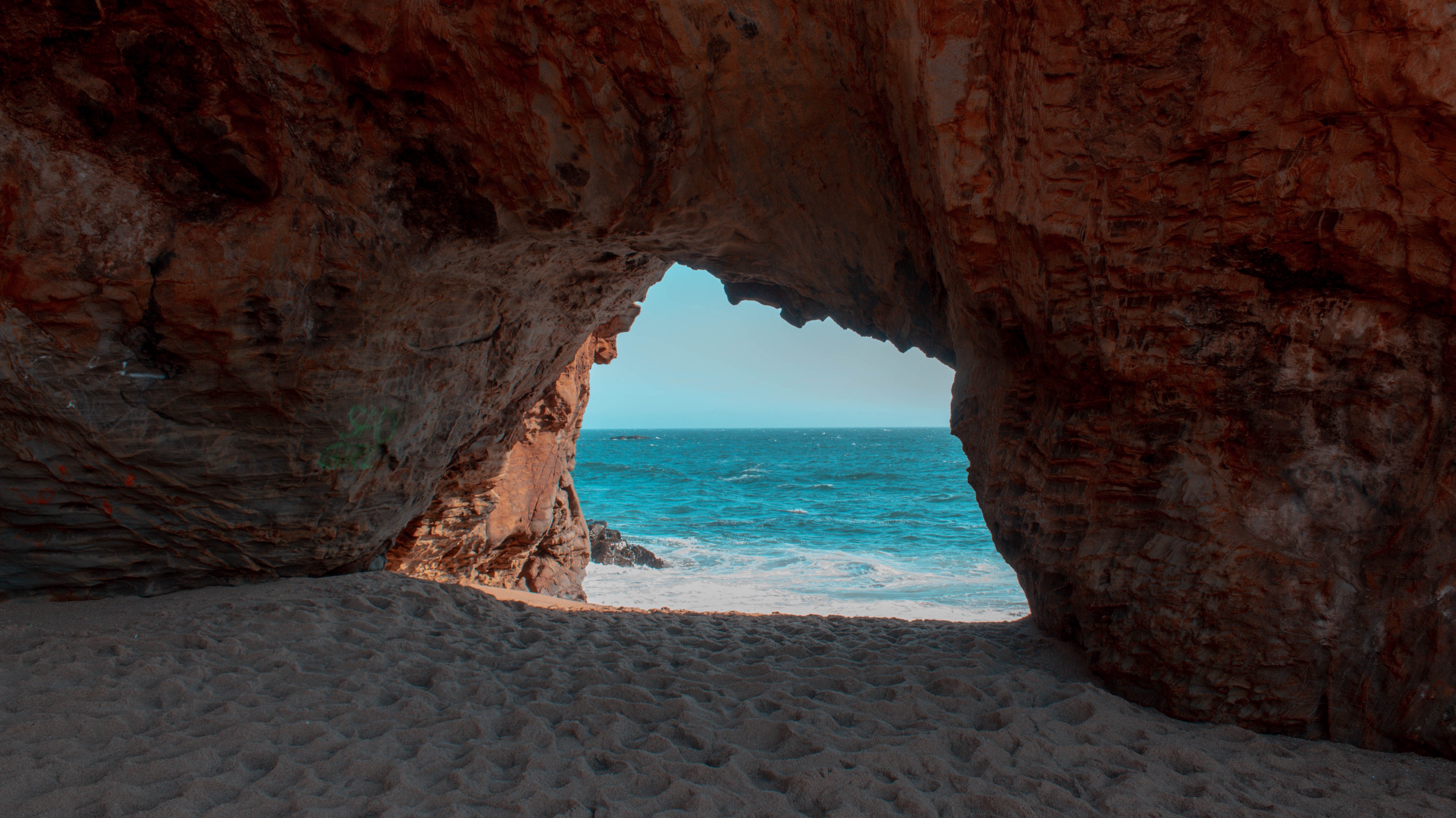 دانلود تصویر زمینه جذاب با طراوت از درون غاری در ساحل