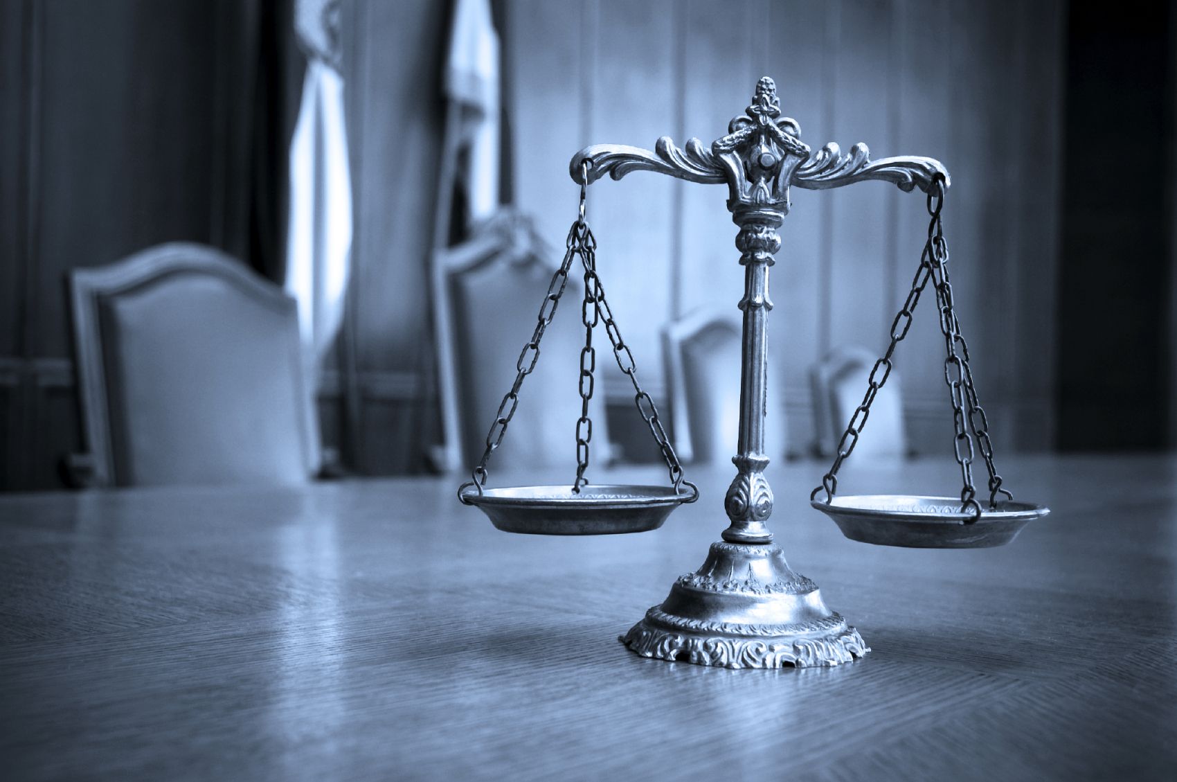 عکس زیبا از ترازوی عدالت بر روی میز چوبی با تم دارک 