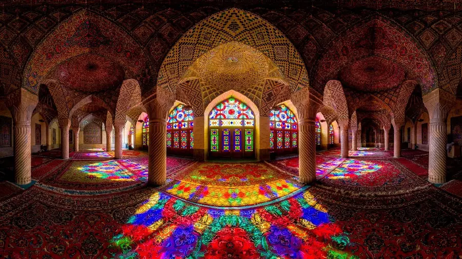 عکس زیبا از بنای سبک معماری اسلامی و زمین فرش شده و پنجره های رنگی