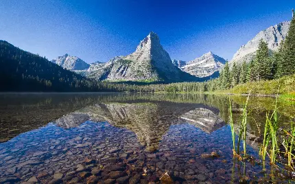 عکس زمینه از انعکاس تصویر کوه در دریاچه شفاف طبیعت