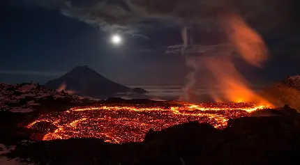 عکس زمینه دهانه آتشفشان و خروج مواد مذاب نورانی در شب تاریک