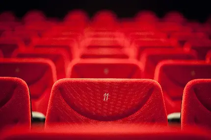 تصویر زمینه تماشایی از صندلی های قرمز سینما