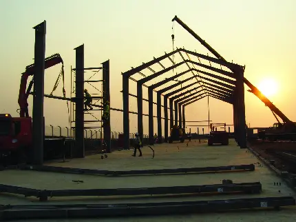 عکس پس زمینه ساختمان فولادی بزرگ درحال ساخت هنگام غروب خورشید