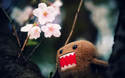 عکس زمینه عروسک پارچه ای ژاپنی در کنار گل صورتی