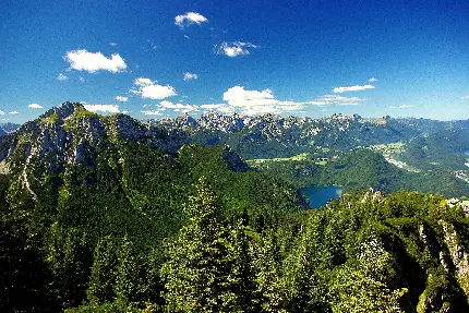 طبیعت سرسبز کوهستانی با کوه های مرتفع و آسمان آبی 