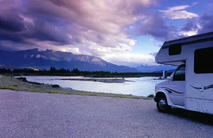تصویر زمینه ماشین کمپر در منظره زیبا کوهستانی کنار دریاچه