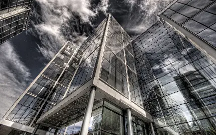 پس زمینه عکس شفافيت و روشنايی نمای شیشه ای در ساختمان با معماری مدرن