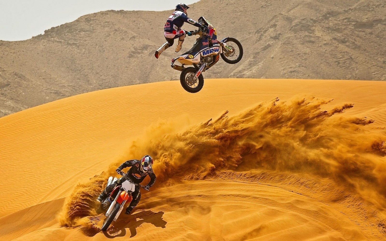 عکس زمینه موتور سواری در خاک بیابان و پرش با تریل