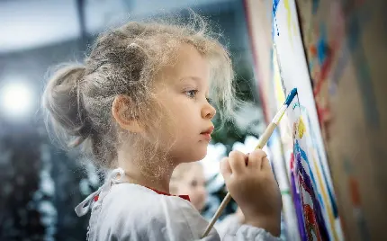 عکس دختر بچه مو طلایی کوچولو نقاشی با قلمو