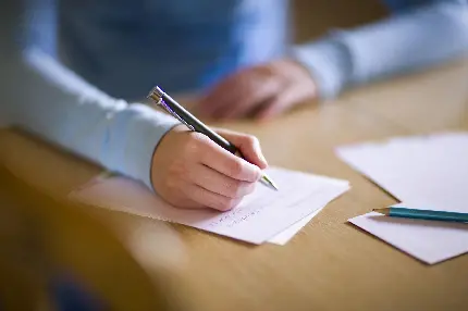 دست نویسنده زن بدون چهره در حال نوشتن با حاشیه مات