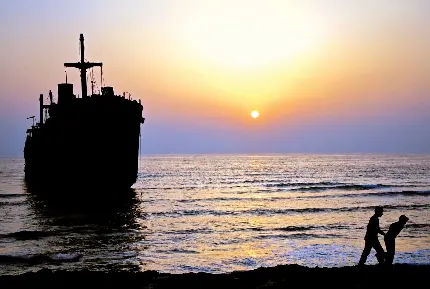 عکس کشتی در دریای جزیره کیش با بکگراند غروب آفتاب 