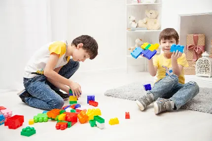 عکس استوک بازی پسر بچه ها با بلوک های خانه سازی در اتاق
