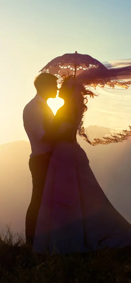 والپیپر عروس و داماد با ژست عاشقانه زیر نور آفتاب با چتر