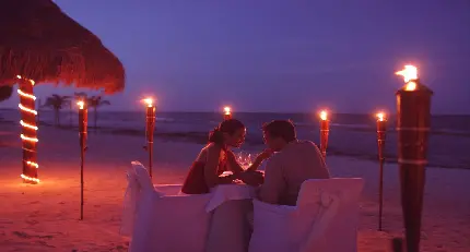 تصویر زمینه رمانتیک شام دونفره در ساحل نورانی برای دسکتاپ
