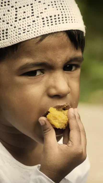 عکس پرطرفدار پسربچه با تیپ اسلامی در حال خوردن خوراکی 