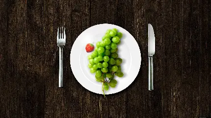 دانلود عکس ظرف غذا و قاشق و چنگال و میوه ی انگور سبز 