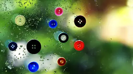 عکس سه بعدی دکمه های رنگارنگ روی شیشه باران خورده