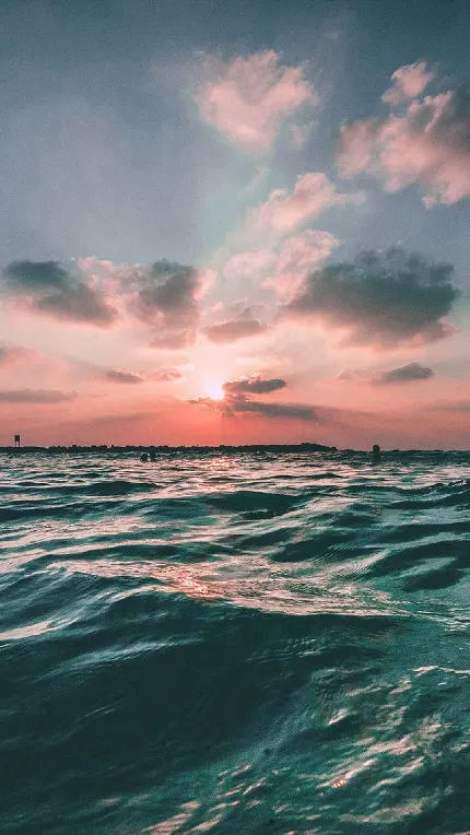 امواج آب دریا زیر نور سرخ رنگ غروب خورشید برای زمینه آیفون