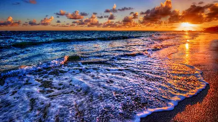 عکس والپیپر غروب خورشید در ساحل با موج های آرام و بی تلاطم