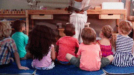 والپیپر با طرح کودکان و مربی در حال قصه گویی در مهدکودک