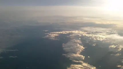 عکس زمینه پرواز بر فراز ابرها در روز آفتابی با کیفیت HD