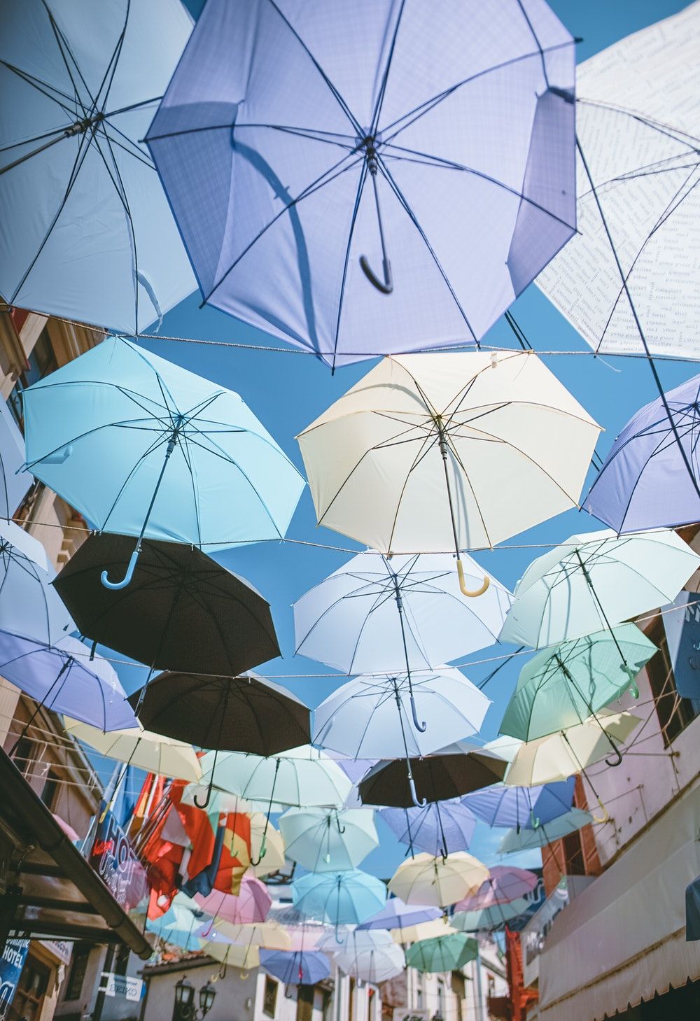 چتر های رنگارنگ آویزان شده در مسیر کوچه ای باریک