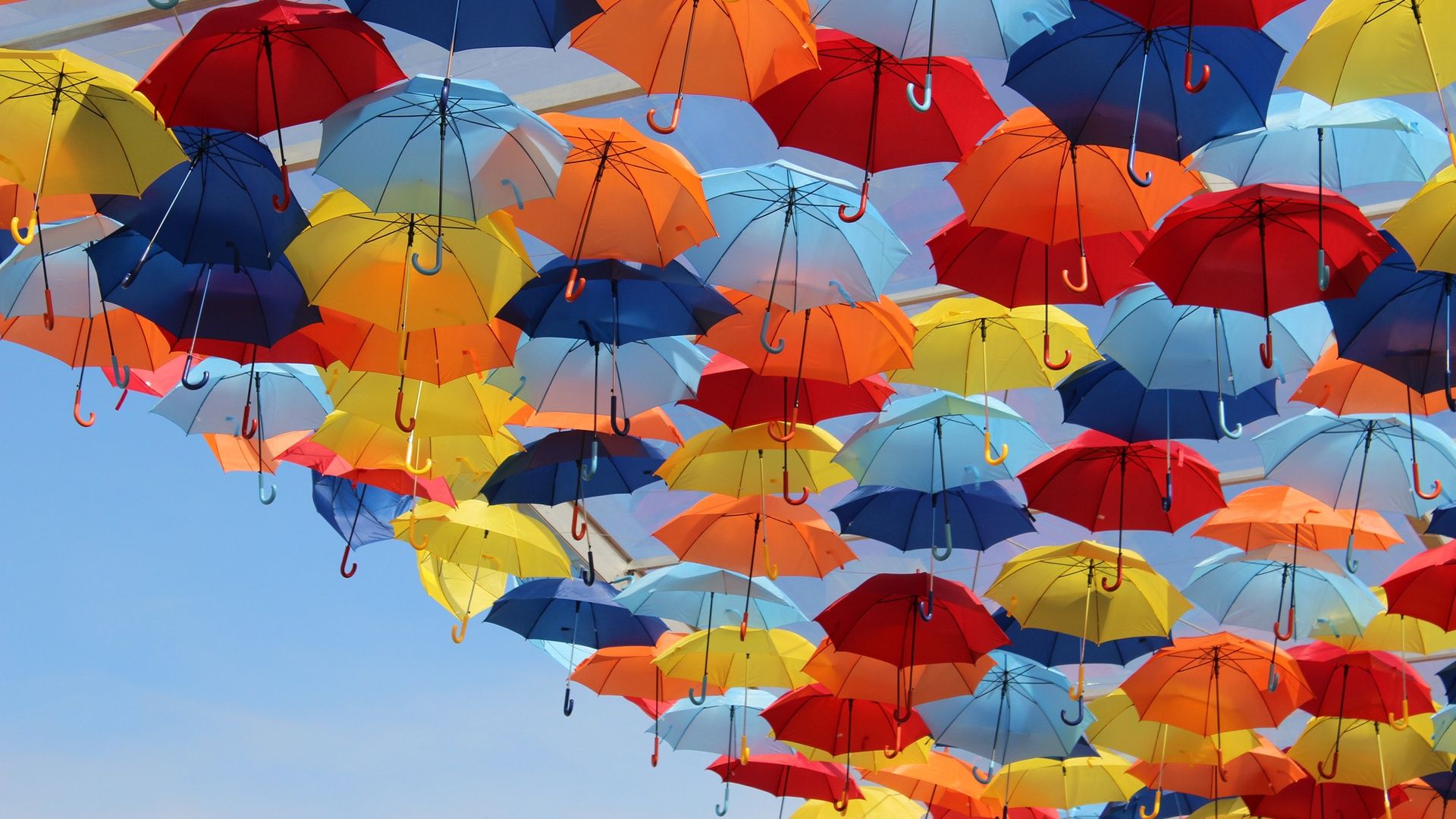 چتر های رنگارنگ به هم پیوسته در آسمان روشن و زیبا