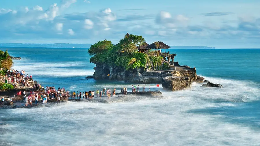 عکس معبد کنار ساحل و موج‌های آب بالی اندونزی
