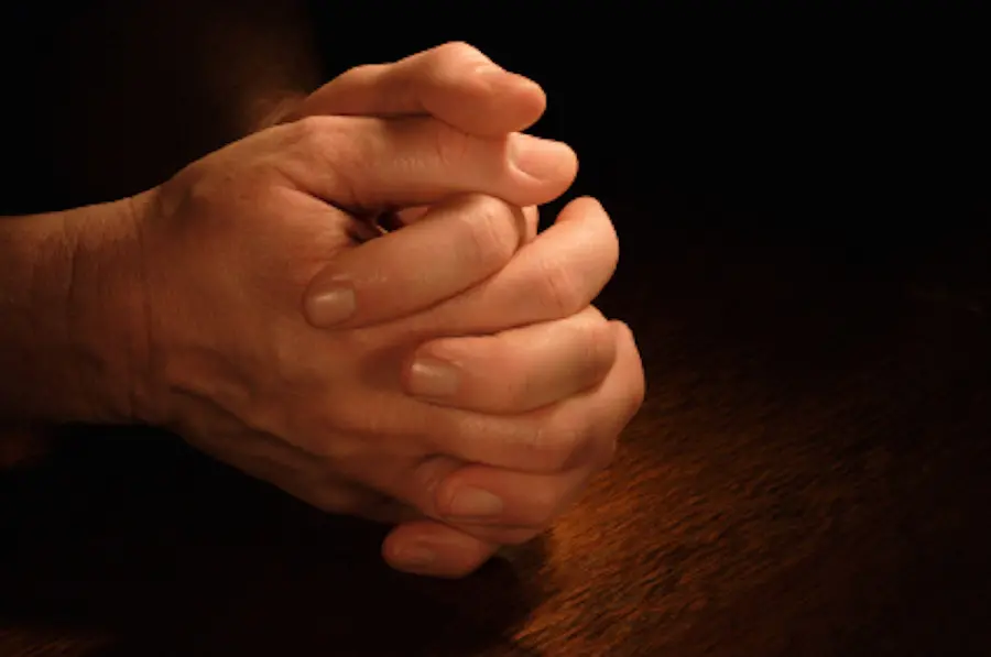 دست‌های گره خورده در هم در حال دعا کردن