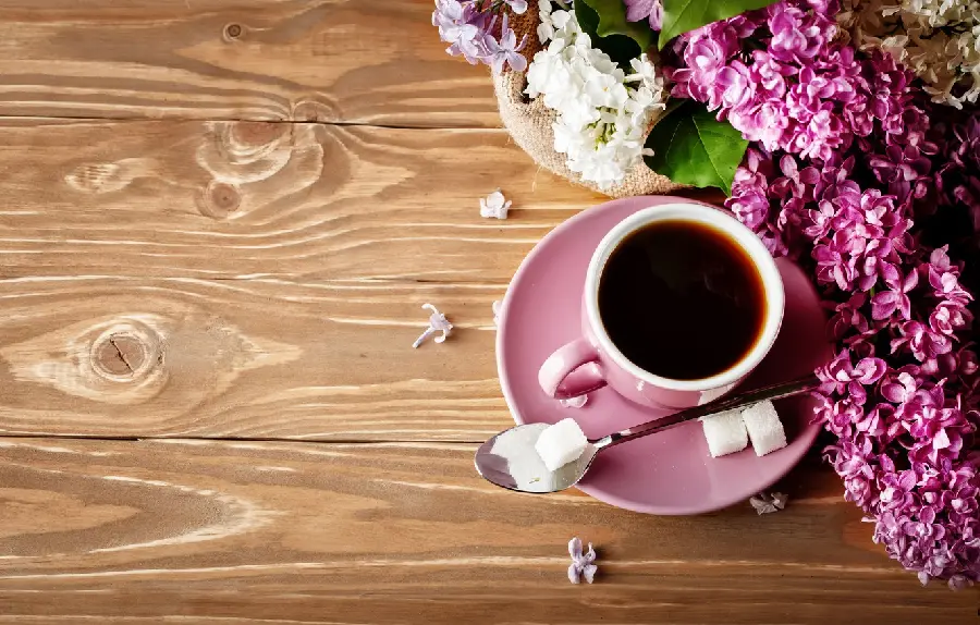 پس زمینه گل‌های بهاری بنفش کنار قهوه برای نوشتن متن