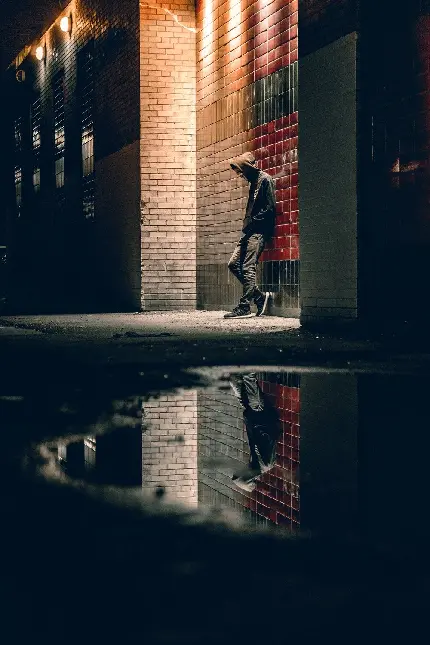 تصویر عکس پسر تنها در کنار ساختمان و تکیه به دیوار