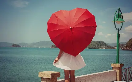 عکس چتر قرمز به شکل قلب در دست دختر