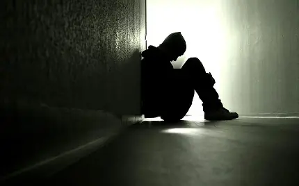 پسر غمگین تنها در کنج دیوار زانو در بغل برای عکس پروفایل