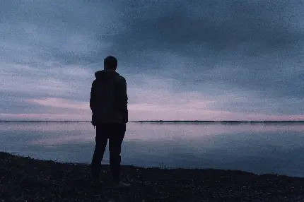 والپیپر پسر تنها و غمگین در کنار دریاچه و هوای تاریک