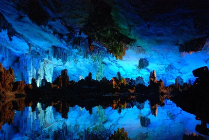 تصویر غار طبیعی بزرگ با کریستال‌های آبی در انعکاس دریاچه