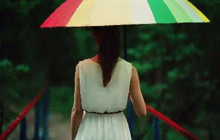عکس واقعی دختر با چتر رنگارنگ در طبیعت